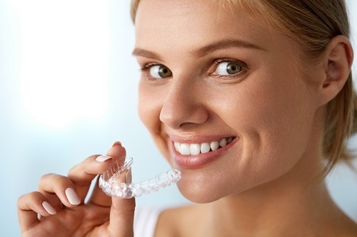 woman holding clear aligner